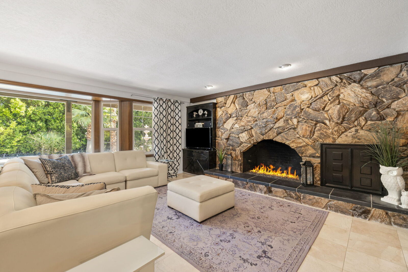 Living room with a floor-to-ceiling stone fireplace and leather seating