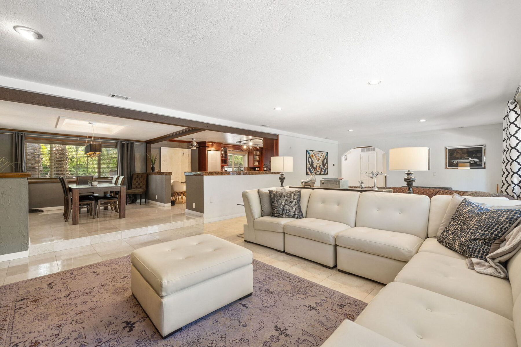 Bright, open living room at Villa 700 with seating, mountain-view windows, and tile floors